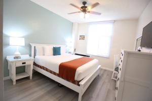 ein weißes Schlafzimmer mit einem Bett und einem Deckenventilator in der Unterkunft Hotel Carmel Santa Monica in Los Angeles