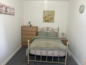 a bedroom with a bed and a dresser at 3 Bedroom Flat in Town Centre in Wellingborough