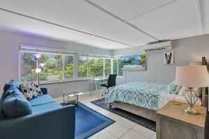 a bedroom with a bed and a couch and a desk at Oasis by Las Olas Lux Getaway in Fort Lauderdale