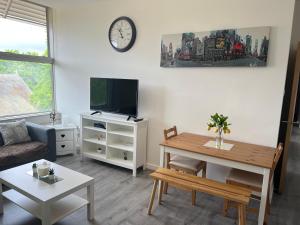 ein Wohnzimmer mit einem Tisch und einem TV in der Unterkunft 3 Bedroom Flat in Town Centre in Wellingborough