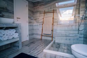 La salle de bains est pourvue d'une douche en verre et de toilettes. dans l'établissement Villa Alenor Nessebar, à Nessebar