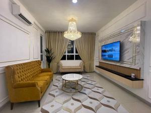 a living room with a couch and a table at 4 Bedroom SeaView Ladang Tanjung Apartment - Ayla Homestay in Kuala Terengganu