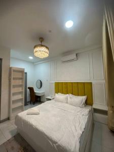 una camera con un grande letto con testiera gialla di 4 Bedroom SeaView Ladang Tanjung Apartment - Ayla Homestay a Kuala Terengganu