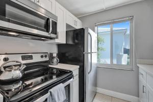 eine Küche mit einem Herd und einem Kühlschrank in der Unterkunft Oasis by Las Olas Lux Getaway in Fort Lauderdale