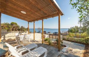 un patio con mesa, sillas y el océano en Stunning Home In Mandre With Kitchen en Mandre