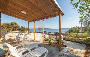 a patio with a table and chairs and the ocean at Nice Home In Mandre With 1 Bedrooms And Wifi in Mandre