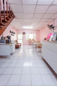 a kitchen with pink walls and white tile floors at Baan Mee Suk Ayutthaya in Phra Nakhon Si Ayutthaya
