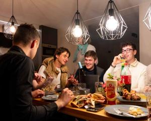 un grupo de hombres sentados alrededor de una mesa comiendo comida en Vakantiewoningen Hoeve Carpe Diem - Dalhem - Aubel - Voeren en Dalhem