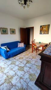 a living room with a blue couch and a table at GreenHouse_Anzio in Anzio