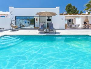 a villa with a swimming pool in front of a house at Villa Olive Tree in Playa Blanca