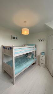 a bedroom with two bunk beds and a light fixture at Ivy Cottage Seahouses Seaside Hot Tub Retreat in Seahouses