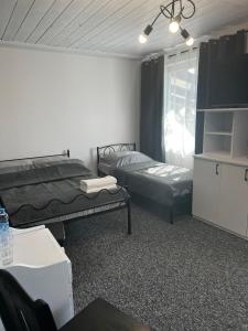 a room with two beds and a tv and a window at Zakątek Bursztynowy in Łeba