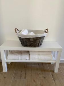 a basket on a white shelf with towels at Vanvitelli Apartments in Caserta