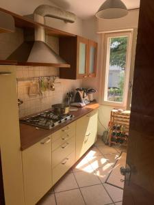 a kitchen with a stove top and a window at Castagneti House -14 km dalla FERRARI in Serramazzoni