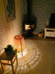 een woonkamer met een lamp en een open haard bij Grazioso appartamento -14 km dalla FERRARI in Serramazzoni