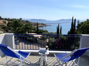 duas cadeiras e uma mesa numa varanda com o oceano em Beautiful summer house 5' from the beach em Karafotaíika