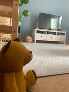 a yellow stuffed animal sitting in a living room with a tv at Castagneti House -14 km dalla FERRARI in Serramazzoni +14 photos