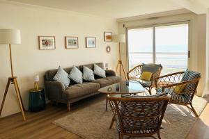 a living room with a couch and chairs and a table at Appart T4 lumineux avec terrasse vue mer in Le Touquet-Paris-Plage