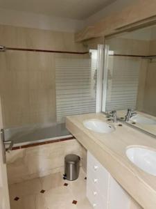 y baño con 2 lavabos, espejo y bañera. en Appart T4 lumineux avec terrasse vue mer, en Le Touquet-Paris-Plage