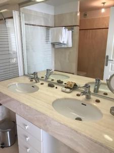 a bathroom with two sinks and a large mirror at Appart T4 lumineux avec terrasse vue mer in Le Touquet-Paris-Plage