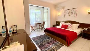 ein Hotelzimmer mit einem Bett mit einer roten Decke in der Unterkunft Aida Hotel in Cıralı