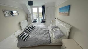 1 dormitorio con 1 cama con sábanas y almohadas a rayas en Ivy Cottage Seahouses Seaside Hot Tub Retreat, en Seahouses