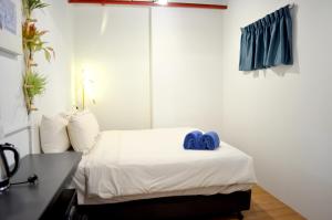 a bedroom with a bed with two blue towels on it at RED ROOM Kuala Lumpur in Kuala Lumpur