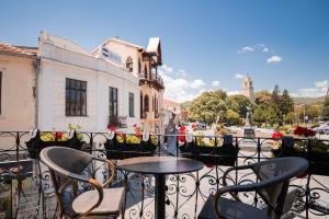 a balcony with tables and chairs on a city street at City House Central in Bitola