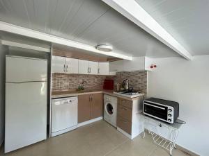 a kitchen with a refrigerator and a microwave at Somos Flats - Mavişehir in Didim