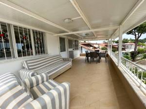 a porch with two couches and a table and chairs at Somos Flats - Mavişehir in Didim
