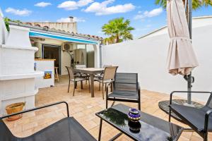 a patio with a table and chairs and an umbrella at WELCS CASA 077 EMP cerca del Mar in Empuriabrava