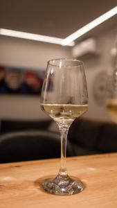 un verre de vin blanc assis sur une table dans l'établissement LocOs Sjenjak, à Osijek
