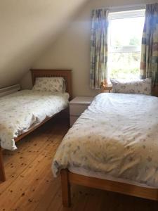a bedroom with two beds and a window at Rosie's Pad in Mayo