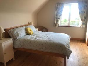 a bedroom with a bed with a yellow stuffed animal on it at Rosie's Pad in Mayo