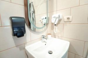 a bathroom with a sink and a mirror and a hair dryer at City House Central in Bitola +40 photos