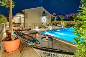 a backyard with a swimming pool at night at Villa Josipa with Private Heated Pool & Close to Beach in Supetar