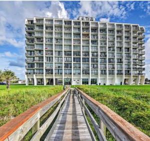 a building with a wooden boardwalk in front of it at Beachfront Islander East Studio in Galveston