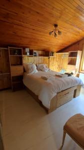 una camera con un grande letto e un soffitto in legno di Appartement meublé classé 3 étoiles de 72 m2, 2 chambres a Morzine
