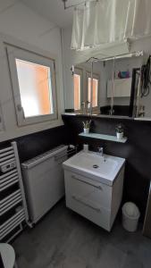 a bathroom with a white sink and a mirror at Appartement meublé classé 3 étoiles de 72 m2, 2 chambres in Morzine