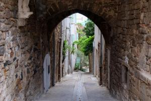 an alley with an archway in a stone building at La Suite Sainte Claire in Hyères