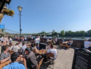 a group of people sitting at tables near the water at Modern 2 Bedroom Flat with private outdoor terrace in London