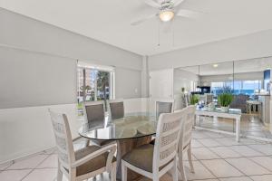 uma sala de jantar com uma mesa de vidro e cadeiras em Island House Beach Resort 3S em Siesta Key