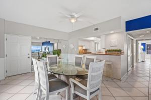 uma sala de jantar e cozinha com uma mesa de vidro e cadeiras em Island House Beach Resort 3S em Siesta Key