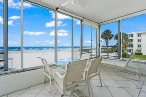 um quarto com uma mesa e cadeiras e vista para a praia em Island House Beach Resort 3S em Siesta Key