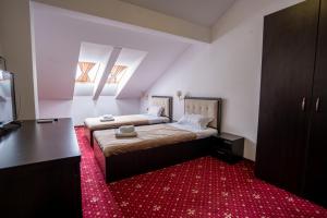 a bedroom with two beds and a red carpet at HOTEL N Residence in Timişoara