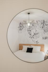 1 dormitorio con un gran espejo circular sobre una cama en Charmant T3 en Centre Ville #1, en Embrun