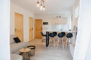a living room and kitchen with a couch and a table at Charmant T3 en Centre Ville #1 in Embrun