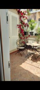 eine Terrasse mit 2 Stühlen, einem Tisch und Blumen in der Unterkunft San Francesco Rooms and Apartment with Terrace in Palermo in Palermo