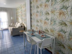 ein Wohnzimmer mit einem Tisch und Stühlen mit einer Tapete in der Unterkunft La Sal Marina 2A in Las Palmas de Gran Canaria