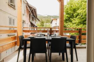 a black table and chairs on a balcony at Charmant T3 en Centre Ville #1 in Embrun